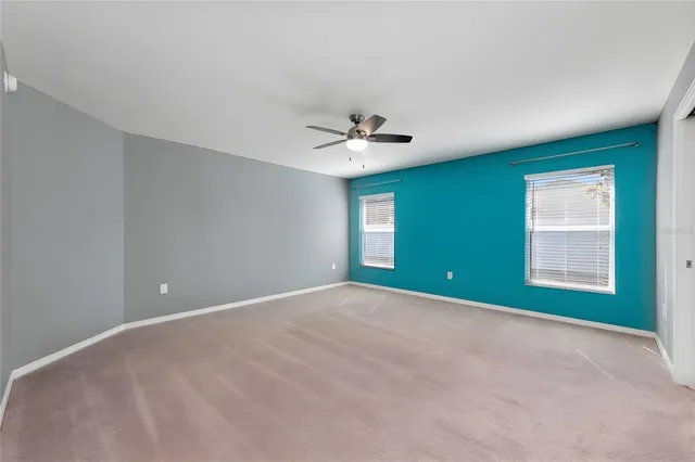 a view of an empty room with a ceiling fan