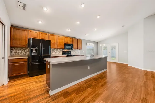 a kitchen with stainless steel appliances granite countertop a refrigerator and a stove top oven