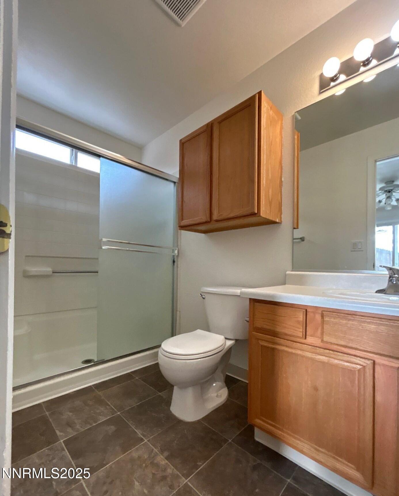 7470 Rodin Court Sun Valley, NV 89433 - Photo 11 of 23 a bathroom with a sink a toilet and a mirror