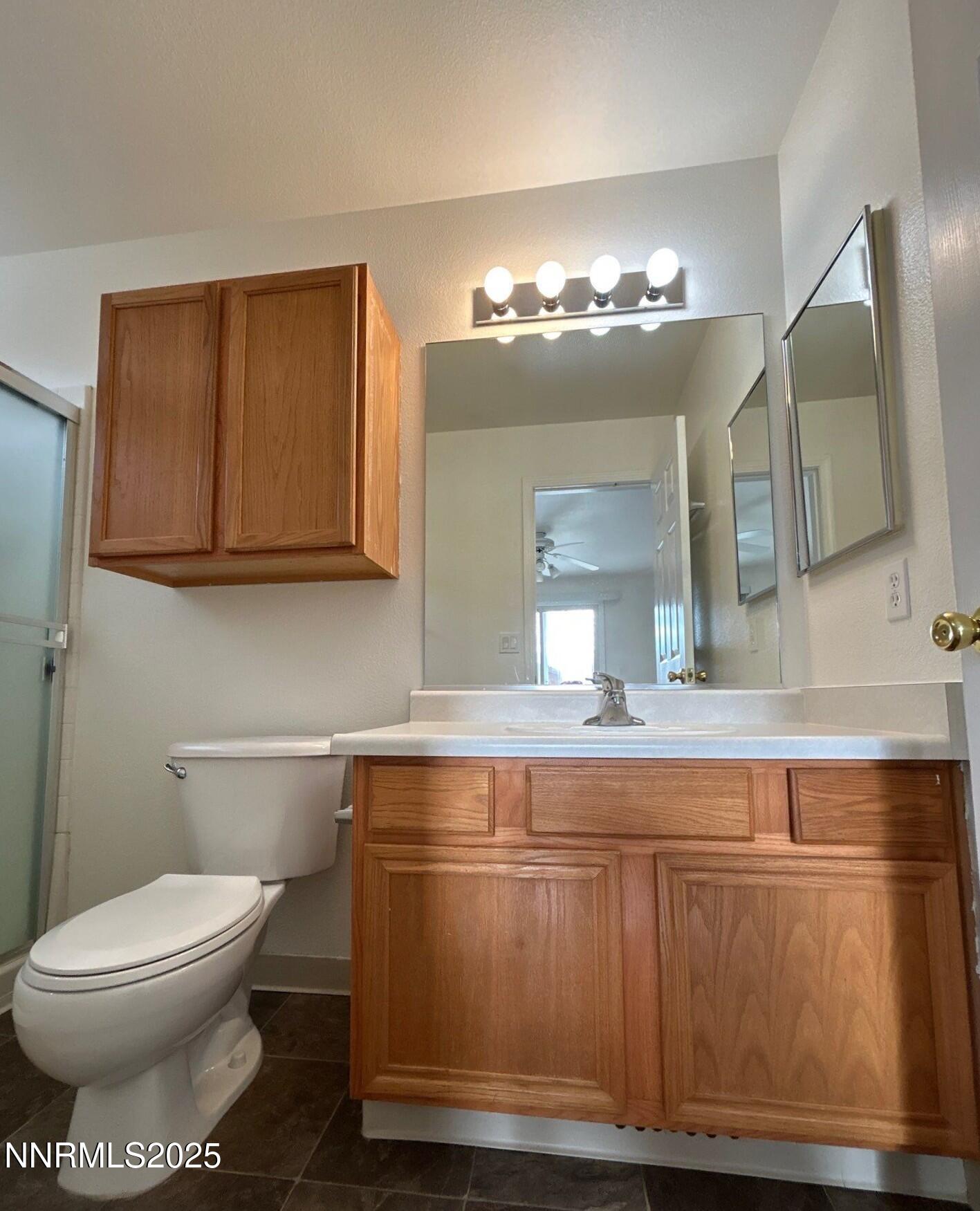 7470 Rodin Court Sun Valley, NV 89433 - Photo 12 of 23 a bathroom with a toilet a sink and mirror