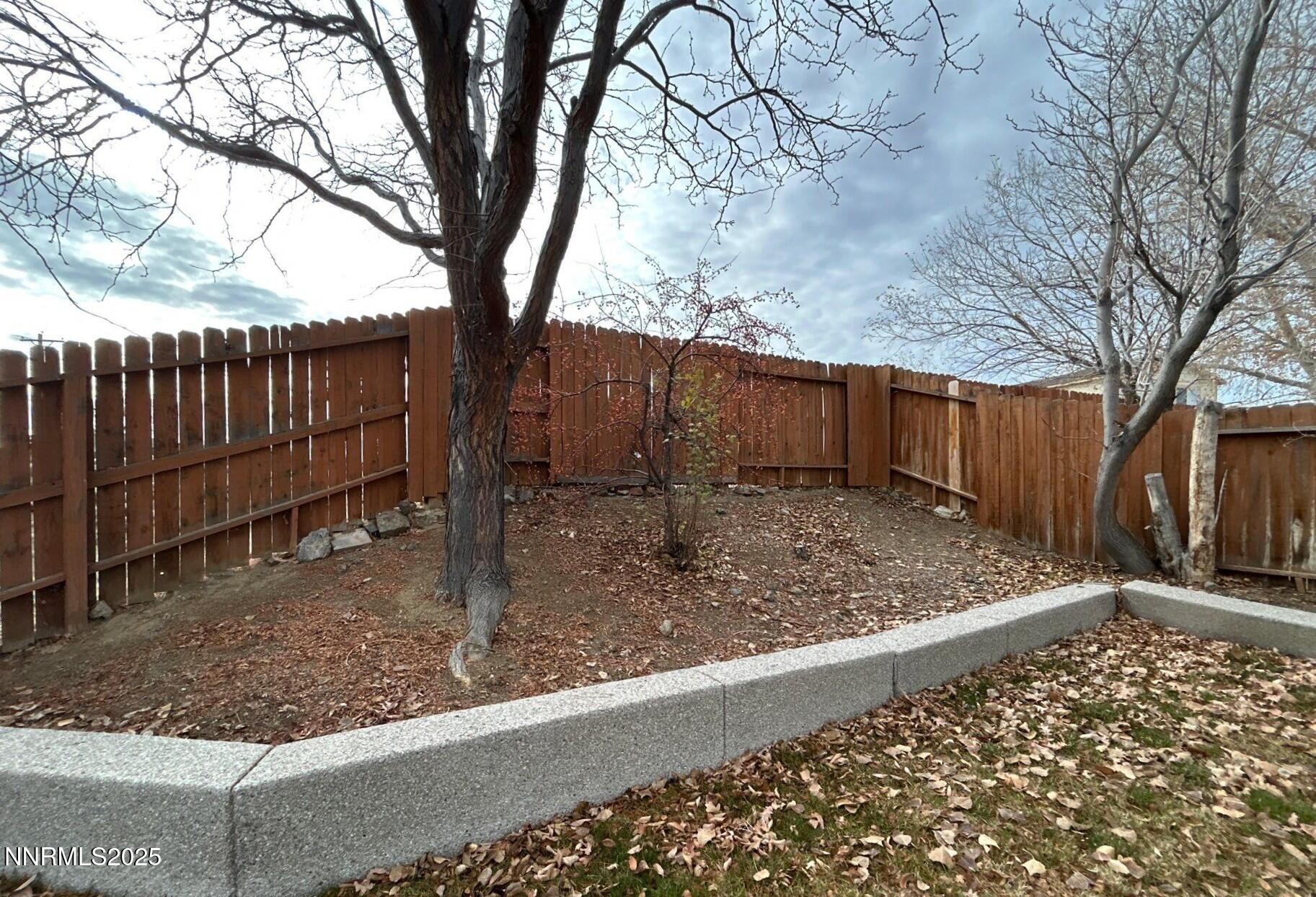 7470 Rodin Court Sun Valley, NV 89433 - Photo 19 of 23 a view of a backyard with wooden fence