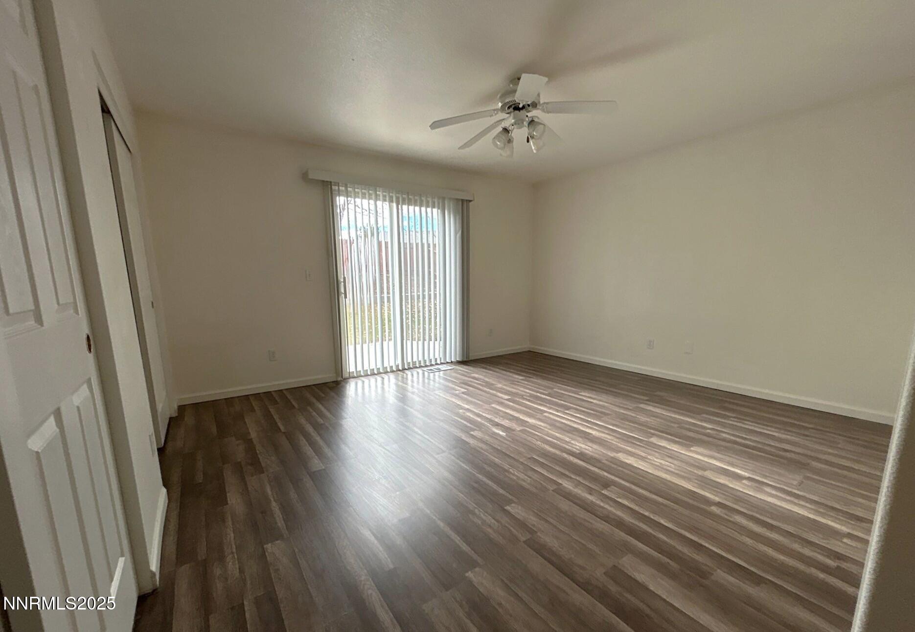 7470 Rodin Court Sun Valley, NV 89433 - Photo 9 of 23 a view of an empty room with wooden floor and a window