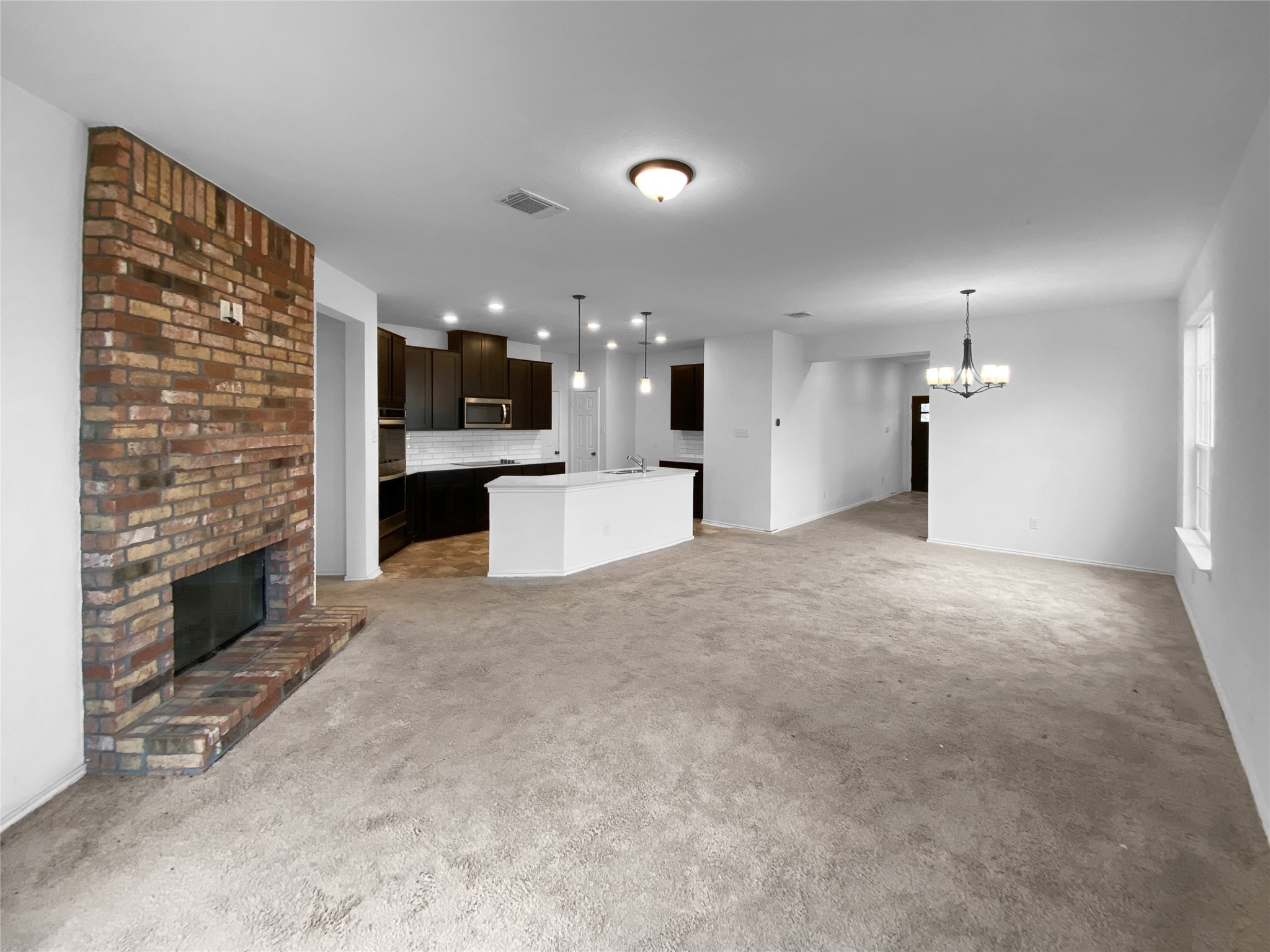 932 Yellow Ribbon Trail Jarrell, TX 76537 - Photo 5 of 26 a view of a kitchen with a sink and a fireplace