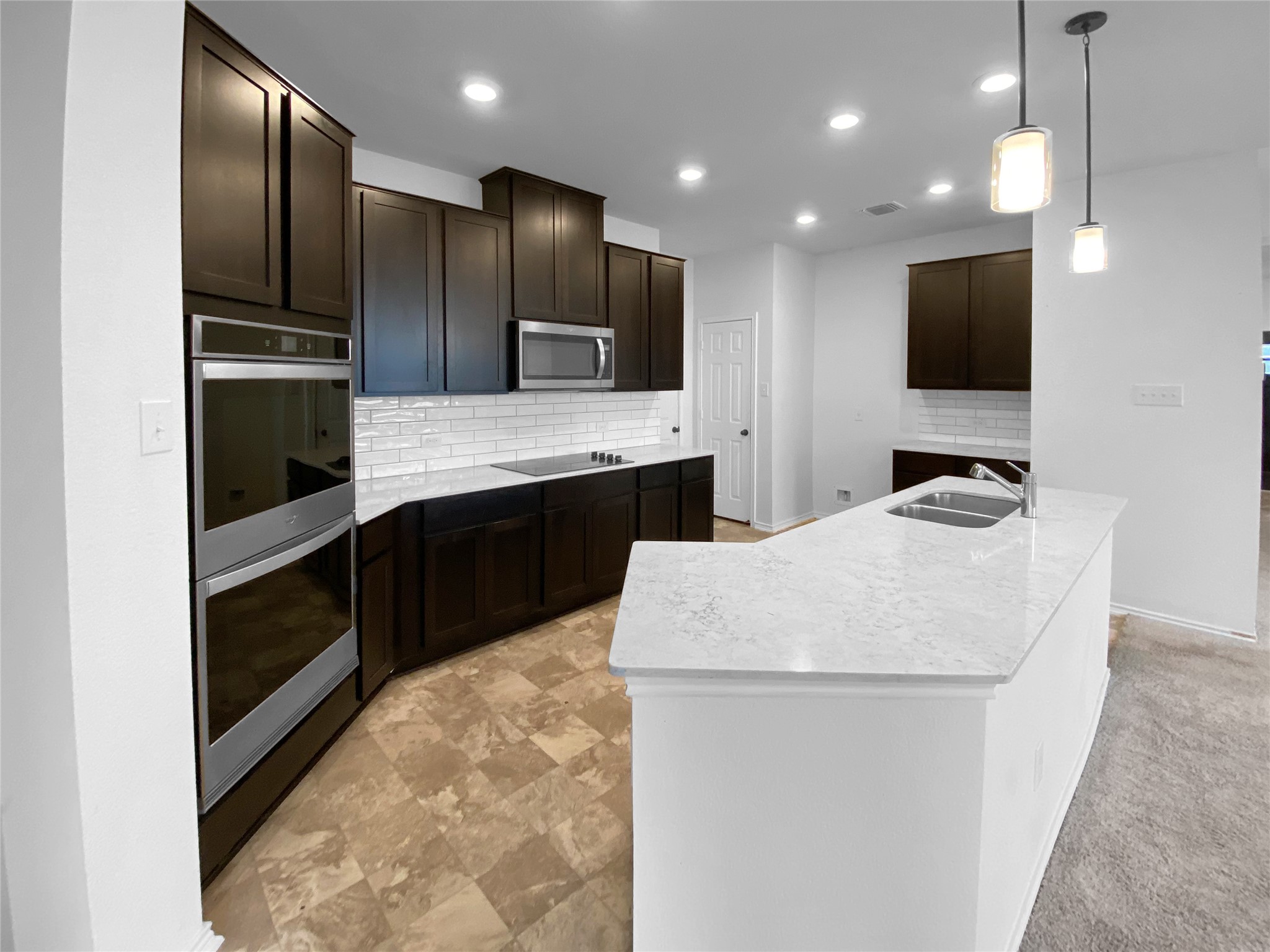 932 Yellow Ribbon Trail Jarrell, TX 76537 - Photo 7 of 26 a kitchen with kitchen island stainless steel appliances a sink and a refrigerator