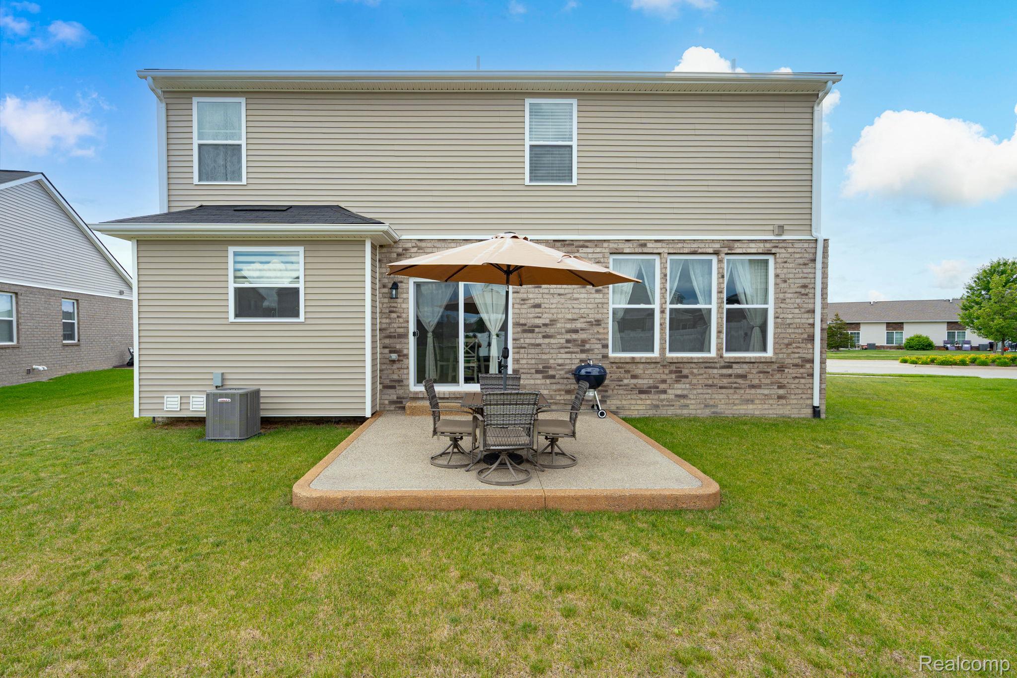 48904 Carnegie Way Macomb, MI 48042 - Photo 5 of 34 Rear exterior featuring a patio, sliding glass door, and multiple windows