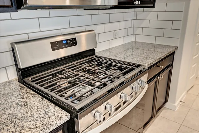 a kitchen with stainless steel appliances granite countertop a refrigerator and a stove top oven