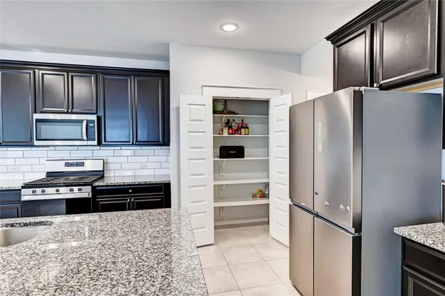 a kitchen with granite countertop a refrigerator and a sink