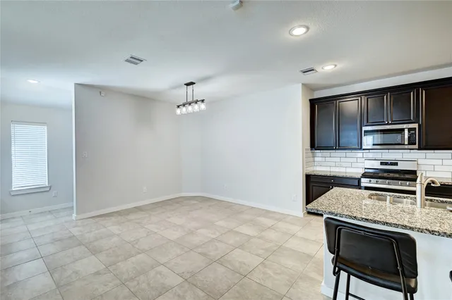 a kitchen with stainless steel appliances granite countertop a stove and a refrigerator with white cabinets
