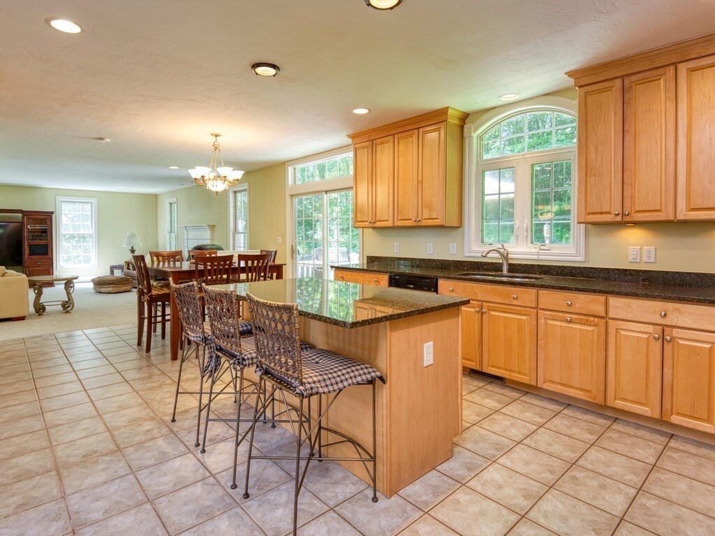 126 Walnut Street Shrewsbury, MA 01545 - Photo 8 of 41 a kitchen with stainless steel appliances granite countertop a stove a sink a dining table and chairs