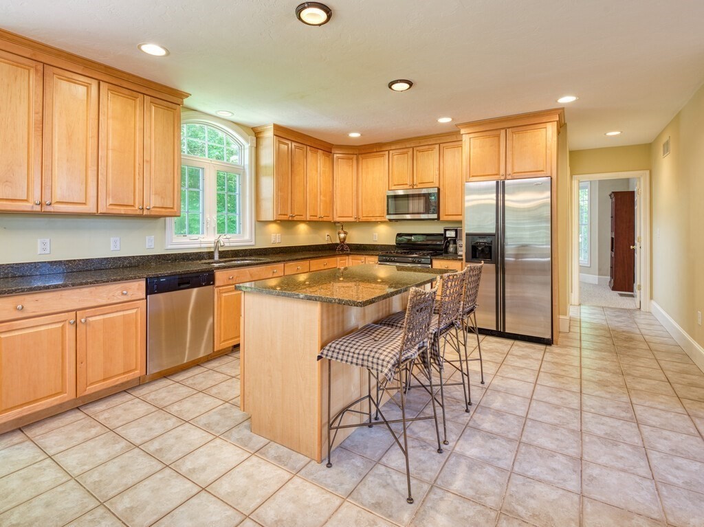 126 Walnut Street Shrewsbury, MA 01545 - Photo 9 of 41 a kitchen with stainless steel appliances granite countertop a stove a sink a microwave and a refrigerator