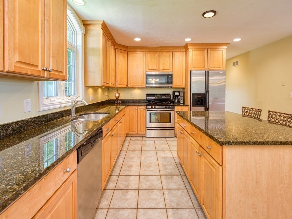 126 Walnut Street Shrewsbury, MA 01545 - Photo 10 of 41 a large kitchen with granite countertop a large counter top stainless steel appliances a sink a window and cabinets