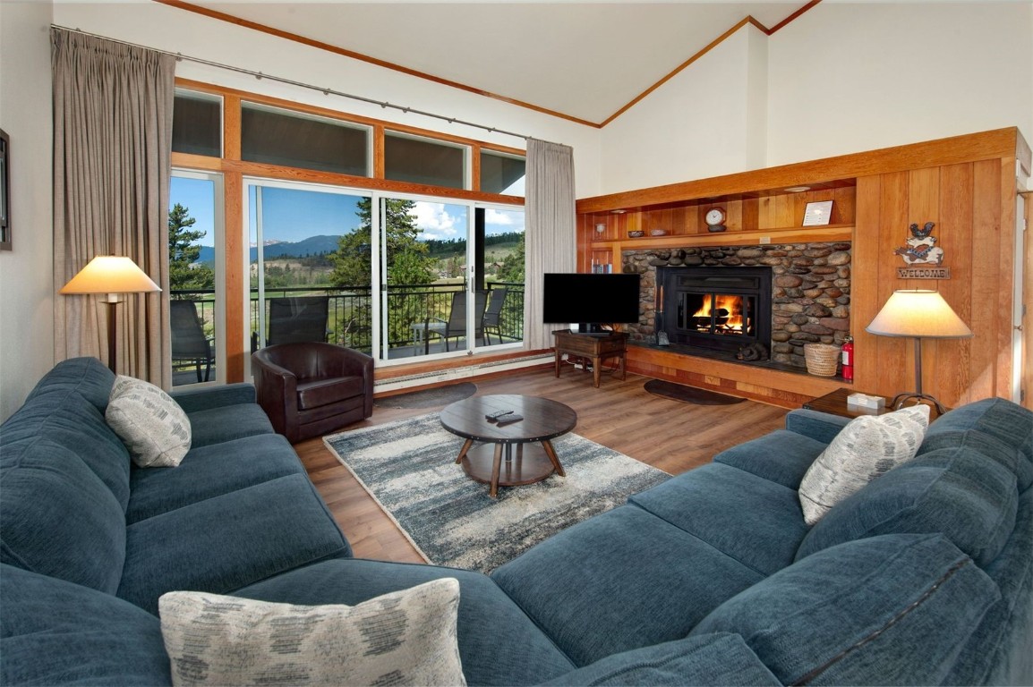 a living room with furniture a fireplace and a large window