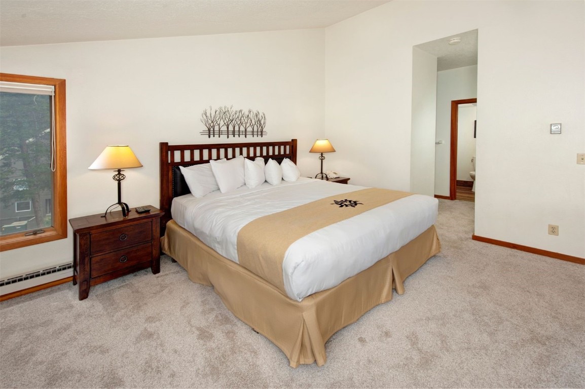 21630 Highway 6, Unit 2150 Keystone, CO 80435 - Photo 20 of 46 a spacious bedroom with a bed and a lamp on table