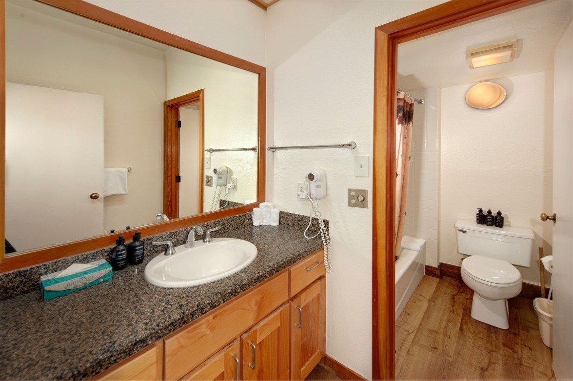 21630 Highway 6, Unit 2150 Keystone, CO 80435 - Photo 28 of 46 a bathroom with a granite countertop sink a toilet a mirror and shower