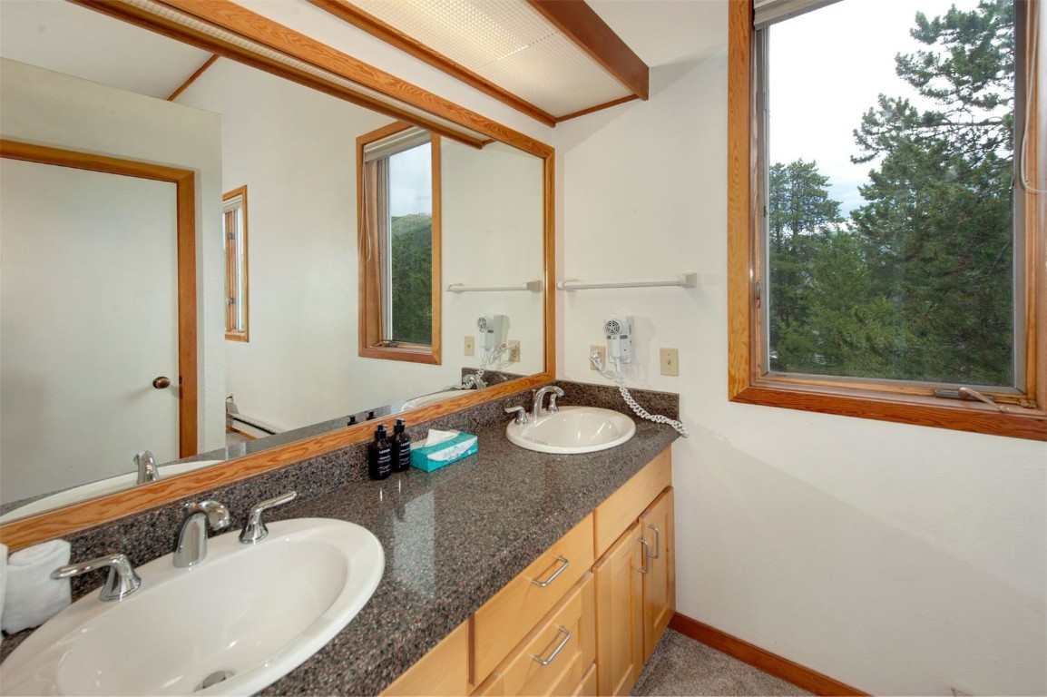 21630 Highway 6, Unit 2150 Keystone, CO 80435 - Photo 33 of 46 a bathroom with a granite countertop sink and a mirror