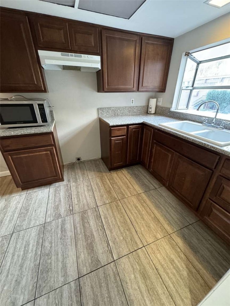 6733 Caro Street, Unit 47 Paramount, CA 90723 - Photo 14 of 25 a kitchen with a sink a stove and cabinets