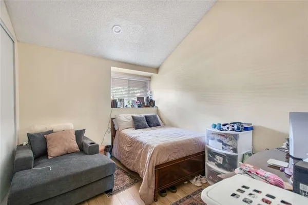 a bedroom with a bed and a wooden floor