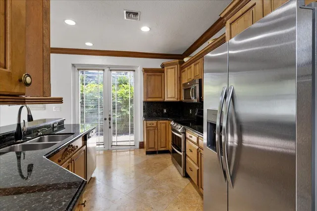 a kitchen with stainless steel appliances granite countertop a sink stove and refrigerator