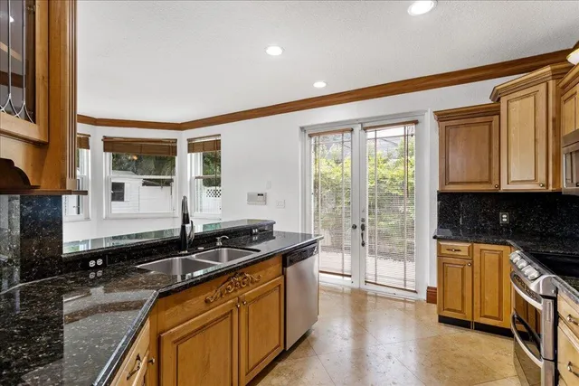 a kitchen with granite countertop a sink and a stove top oven