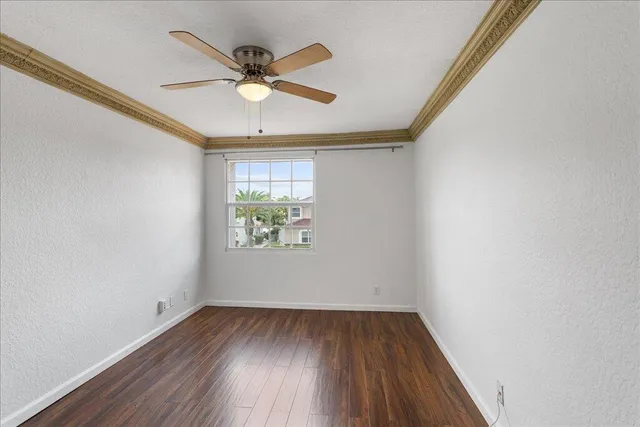 an empty room with window and ceiling fan