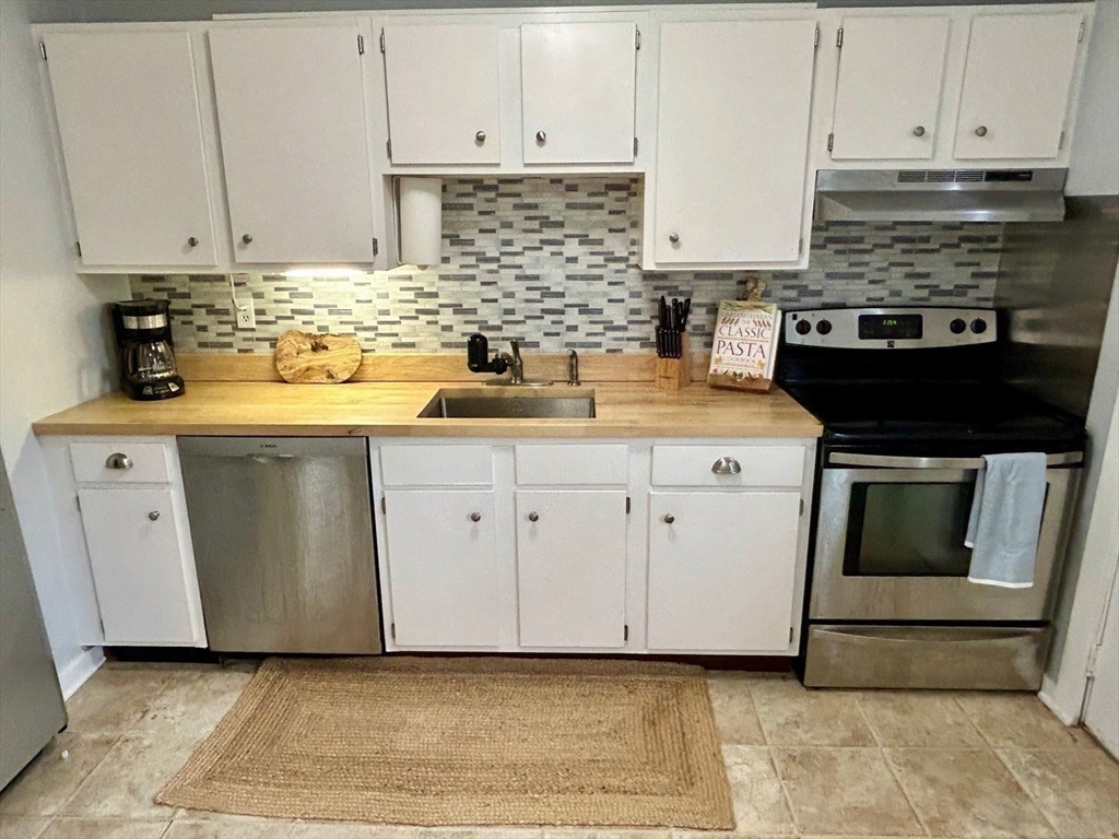 300 Falmouth Road, Unit 6B Mashpee, MA 02649 - Photo 2 of 27 a kitchen with granite countertop white cabinets and stainless steel appliances