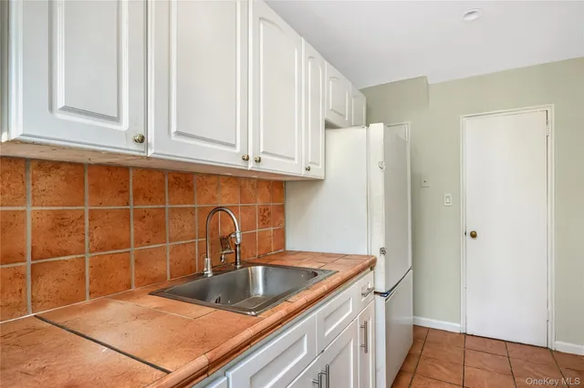 a kitchen with stainless steel appliances granite countertop a sink and a white cabinets