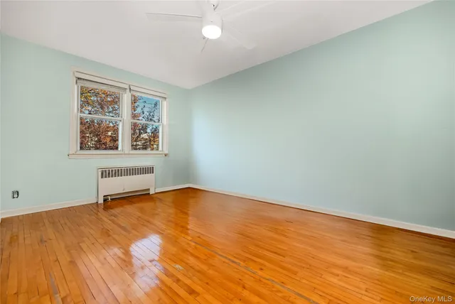 an empty room with a window and wooden floor