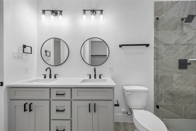 a bathroom with a toilet a sink and a mirror