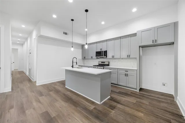 a kitchen with white cabinets and stainless steel appliances