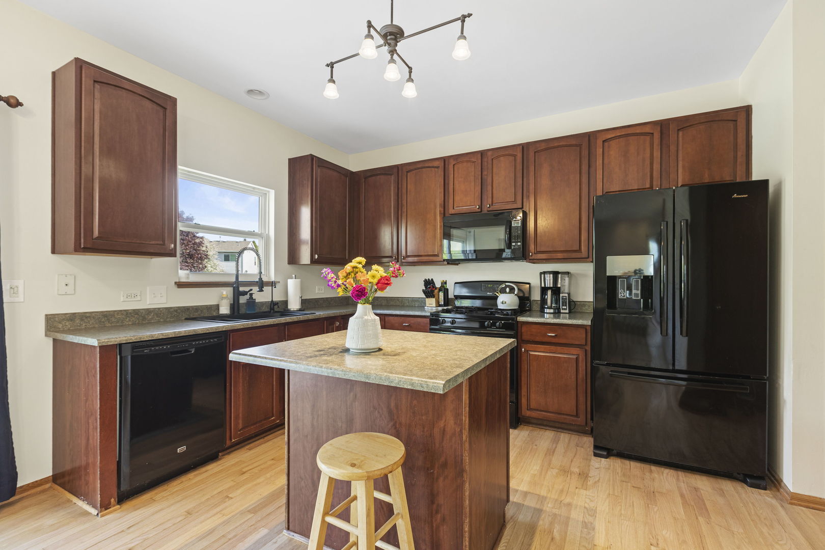 223 Aspen Circle Gilberts, IL 60136 - Photo 5 of 18 a kitchen with stainless steel appliances granite countertop a refrigerator a sink a stove a dining table and chairs