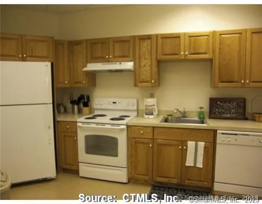 a kitchen with stainless steel appliances granite countertop a refrigerator a stove a sink and white countertops with cabinets