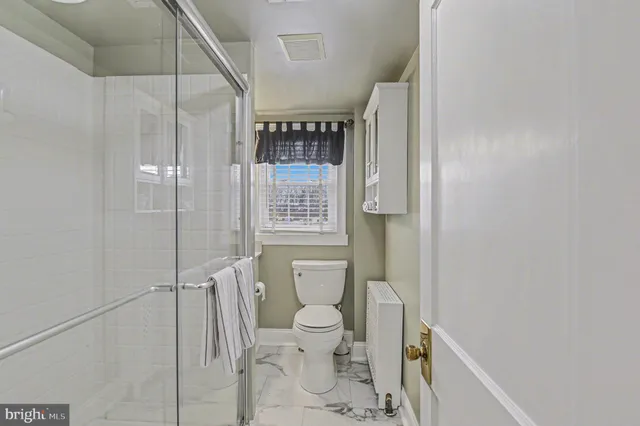 a bathroom with a toilet and a shower