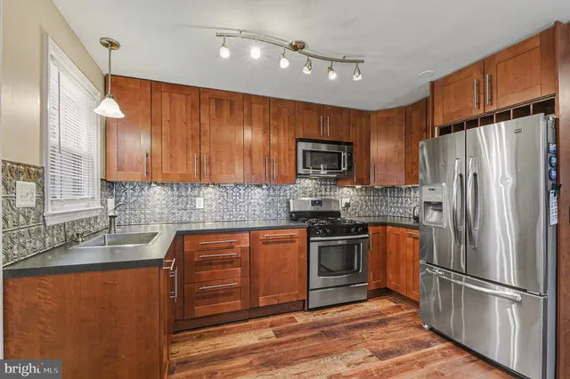 a kitchen with stainless steel appliances granite countertop a refrigerator stove microwave and sink