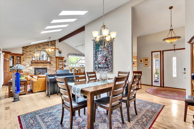 2863 Fallentine Road Sandy, UT 84093 - Photo 22 of 48 Spacious dining area with wood-finish flooring, featuring a decorative chandelier and vaulted ceilings with skylights