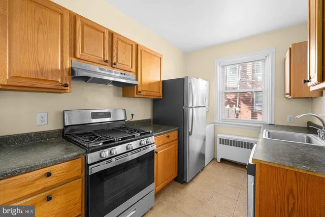 a kitchen with stainless steel appliances granite countertop a refrigerator stove and sink