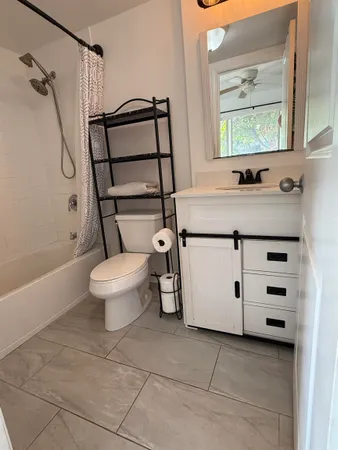 a bathroom with a granite countertop sink toilet and shower