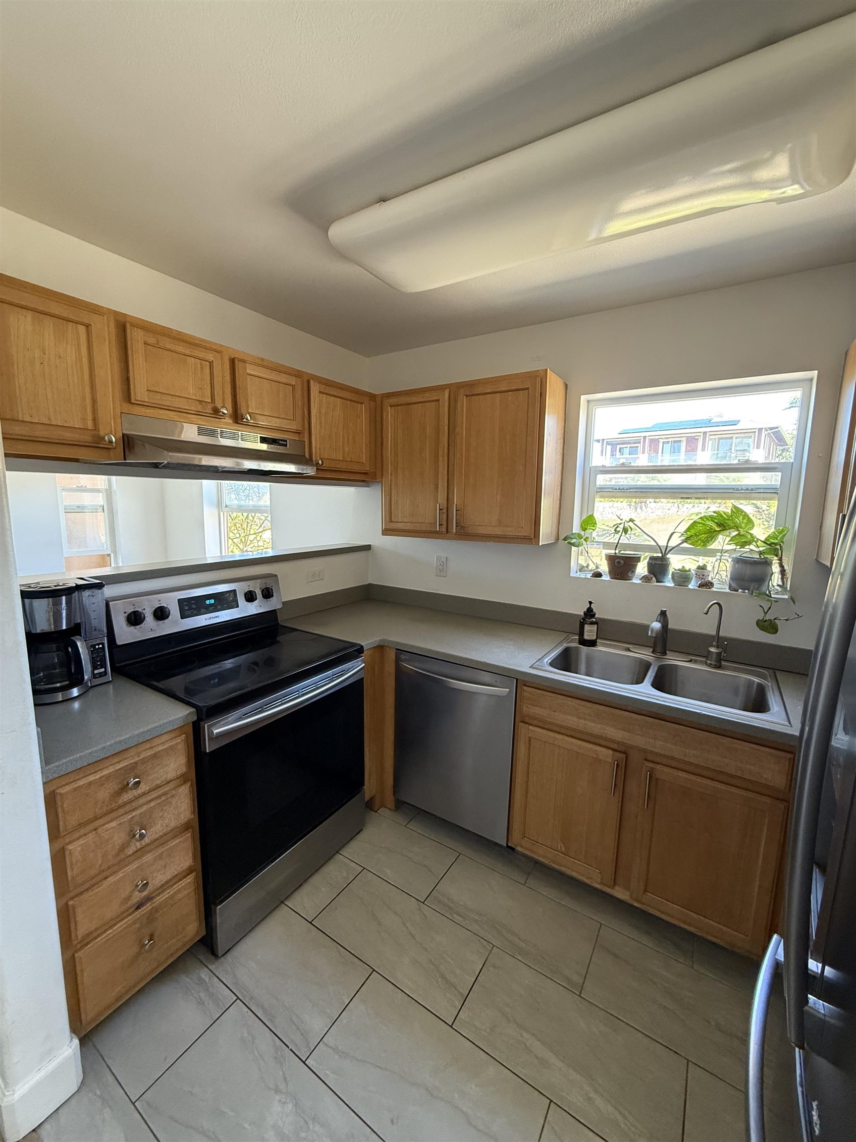 15 Abbey Lane, Unit 423 Lahaina, HI 96761 - Photo 7 of 7 a kitchen with stainless steel appliances granite countertop a sink stove and microwave