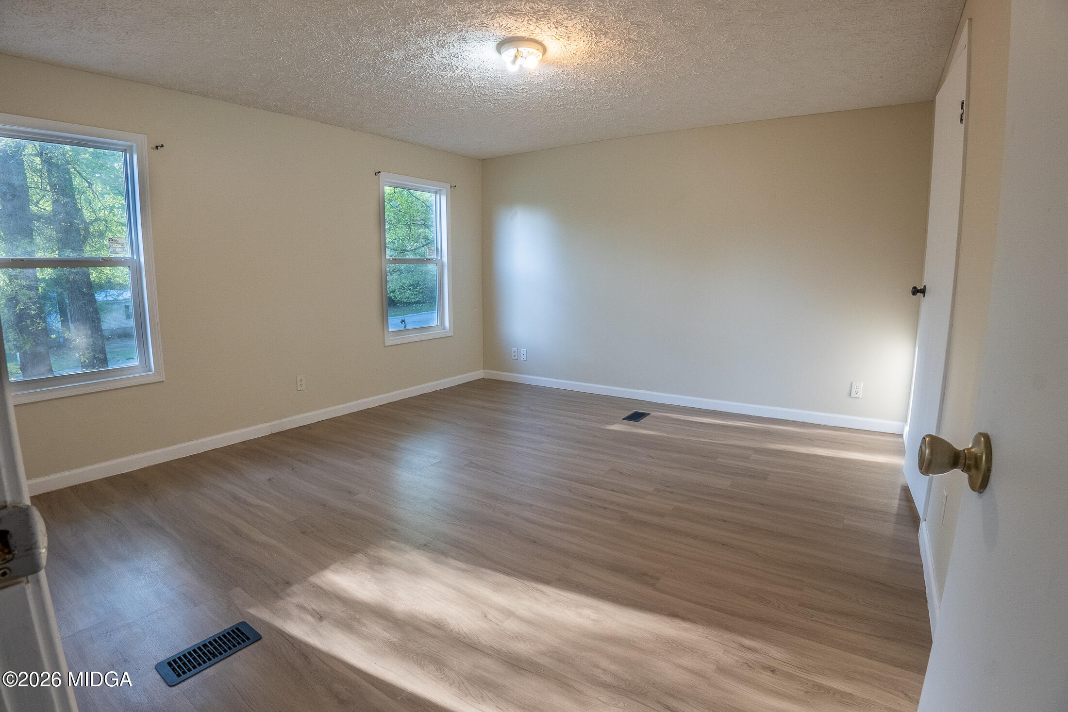 156 Alpine Drive Macon, GA 31206 - Photo 7 of 18 an empty room with wooden floor and windows