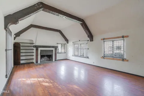a view of an empty room with a fireplace and a window