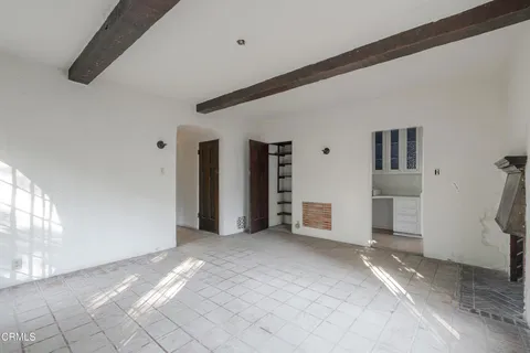 a view of a kitchen with white cabinets and window