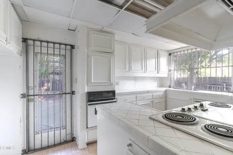 a kitchen with white cabinets and appliances