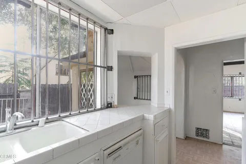 a kitchen that has a sink a stove and white cabinets