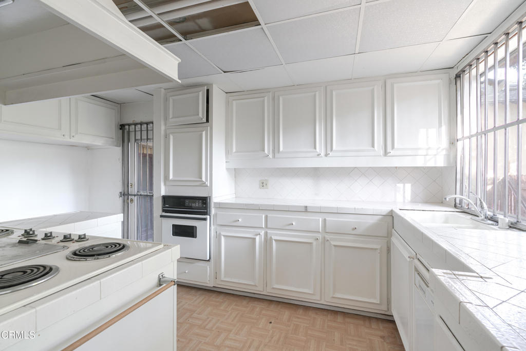 180 West State Street Pasadena, CA 91105 - Photo 22 of 52 a kitchen with white cabinets and appliances