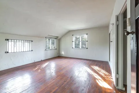 a view of an empty room with wooden floor