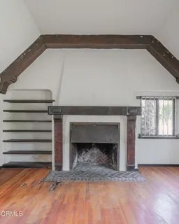 a view of empty room with stairs and a fireplace