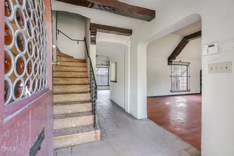 a view of an entryway with wooden floor leading to a furnished livingroom and windows