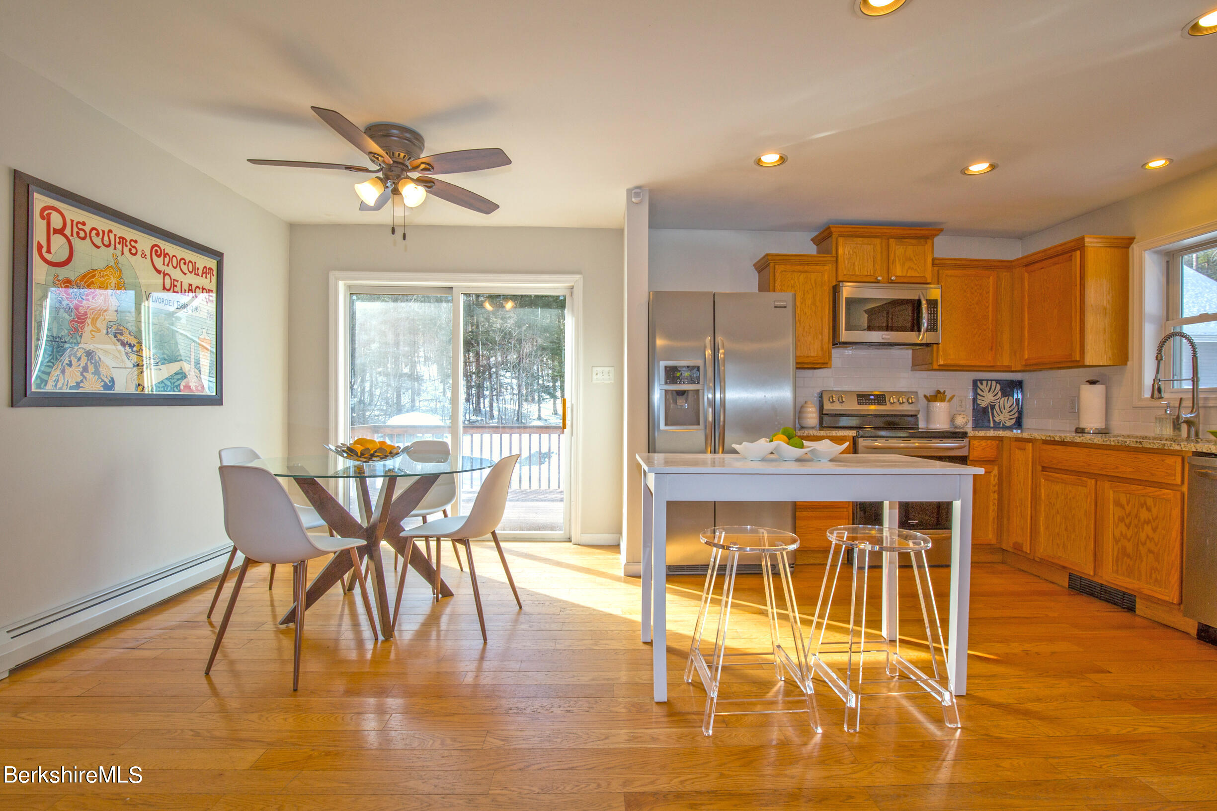 2261 North Main Road Otis, MA 01253 - Photo 8 of 40 a kitchen with stainless steel appliances granite countertop a stove top oven a sink a dining table and chairs with wooden floor