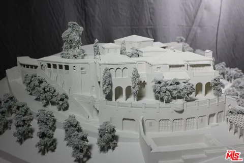 a aerial view of a house with a yard and large trees