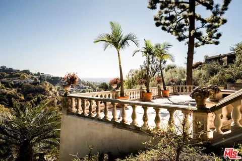 a view of balcony with wooden floor and trees