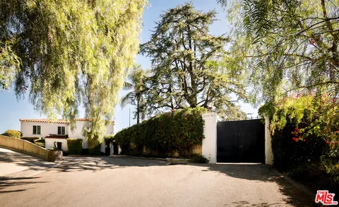 a front view of a house with a yard and tree